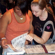 Party guests looking through Heather's Henna Tattoo book of designs